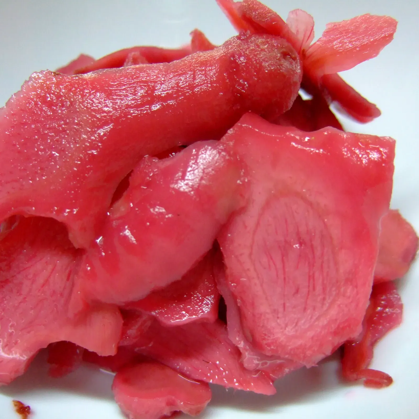 Bright red slices of beni shoga in a white bowl