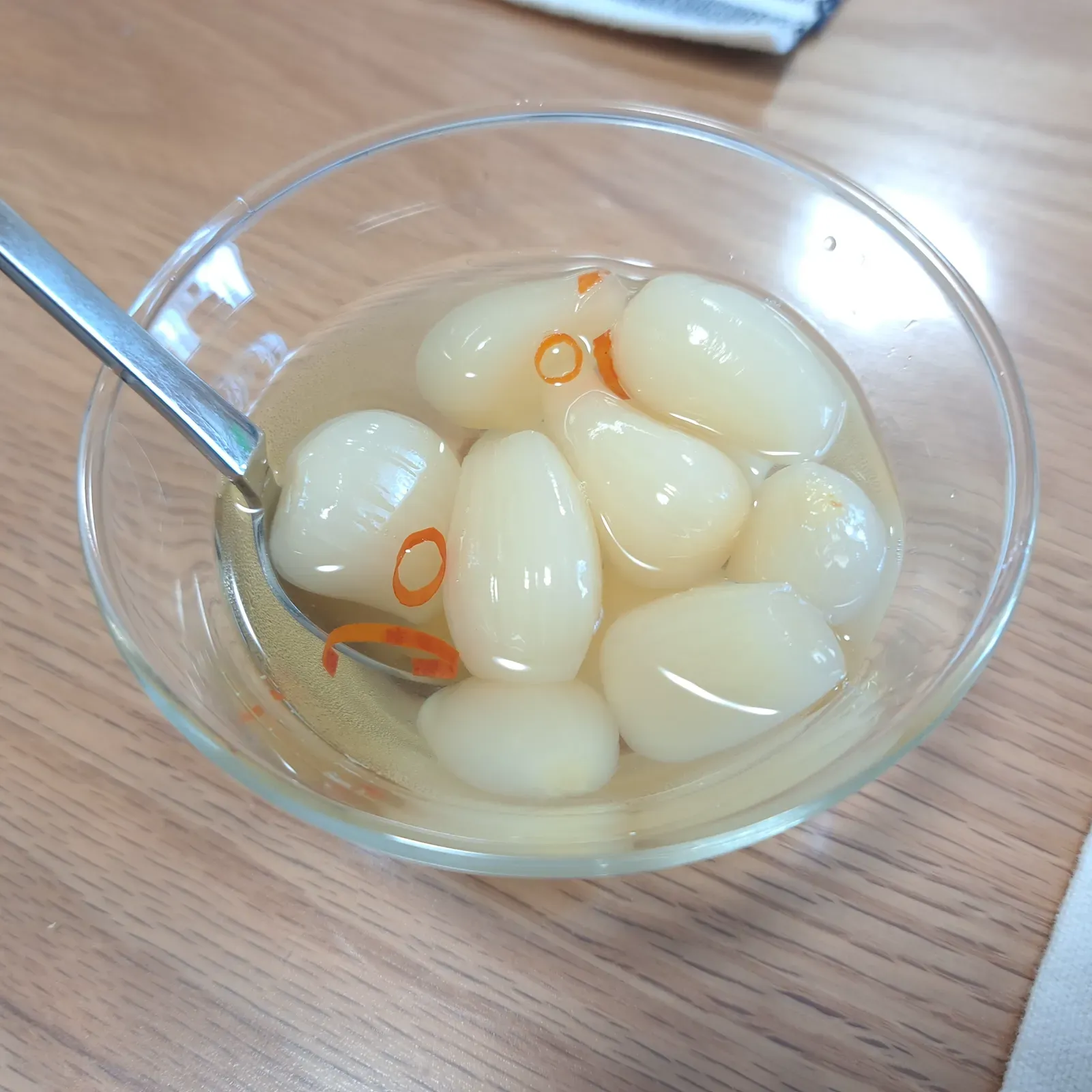 Vita rakkyolökar i en glasskål med strimlor av chili i lagen