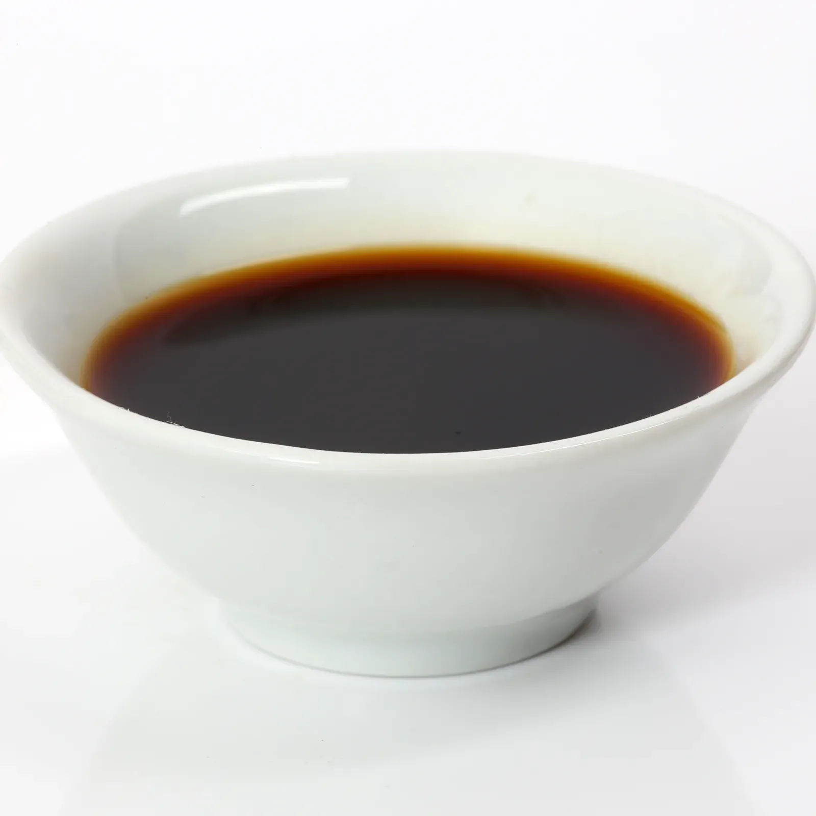 Japanese soy sauce in a small white bowl against a white background