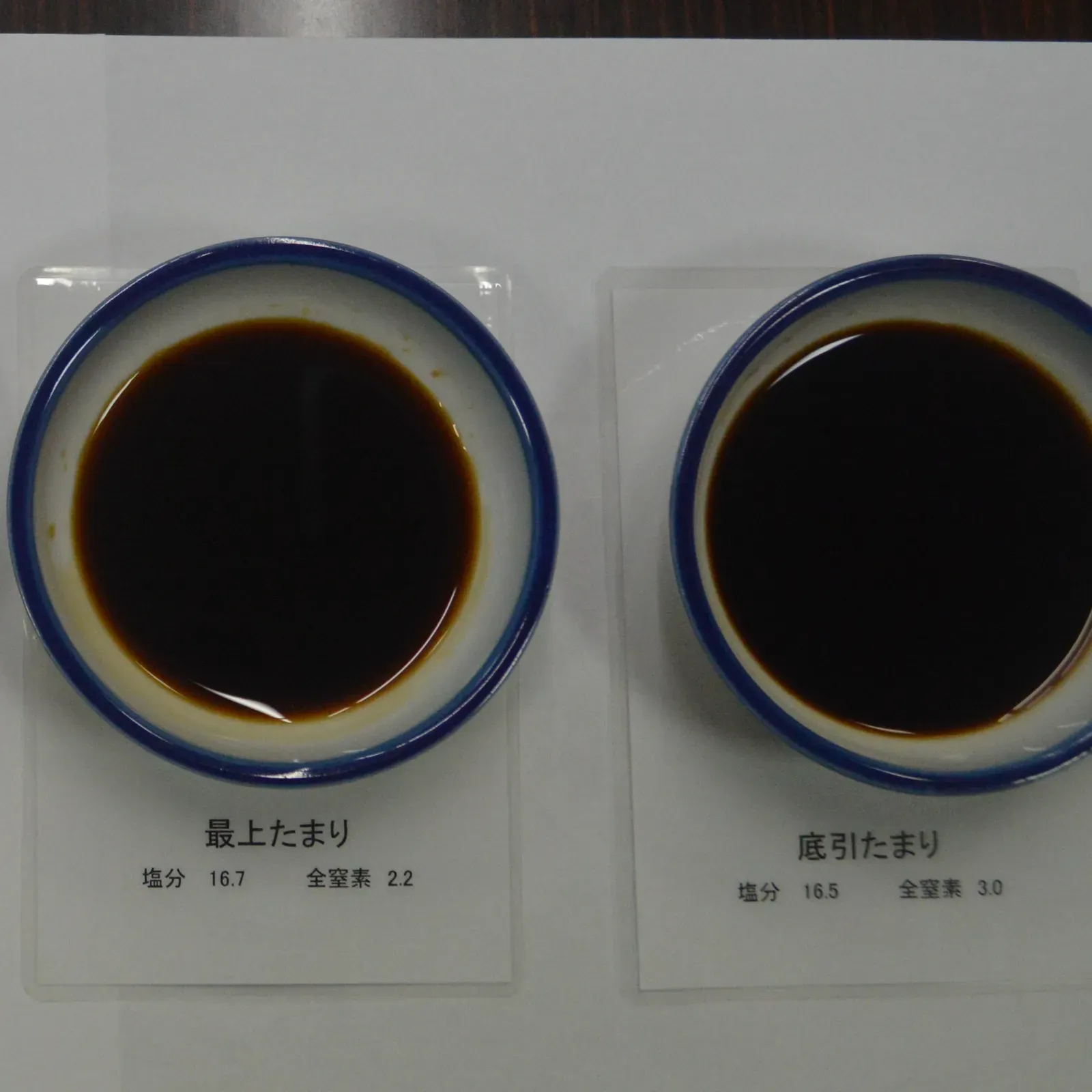Two tasting cups of tamari with labels for grade and salt content